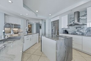 A modern kitchen with marble countertops, stainless steel appliances, and a central island. - Seabliss ~Gulf Front, Luxury~ Walls of Windows!! (DESTIN)