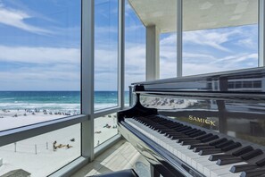 A grand piano with 'SAMICK' branding, positioned in a spacious room with large windows overlooking a beach. - Seabliss ~Gulf Front, Luxury~ Walls of Windows!! (DESTIN)