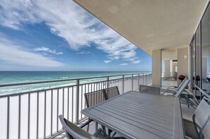 A balcony with a view of the ocean and beach, featuring a table and chairs. - Seabliss ~Gulf Front, Luxury~ Walls of Windows!! (DESTIN)