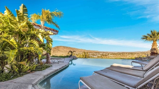 A poolside area with lounge chairs and tropical plants. - ** 4BR, Absolute Privacy, Jacuzzi, Pool Heating Can Be Added** (Palm Springs)