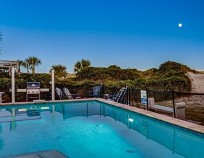 A pool area with a grill, lounge chairs, and a sign indicating a 0.5L water fee. - Private Heated Pool, Beach Access, All King Beds (Tybee Island)