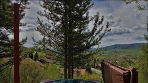 A hot tub on a wooden deck with a view of a mountainous landscape. - Private Home with Great Views & Hot Tub (Steamboat Springs)