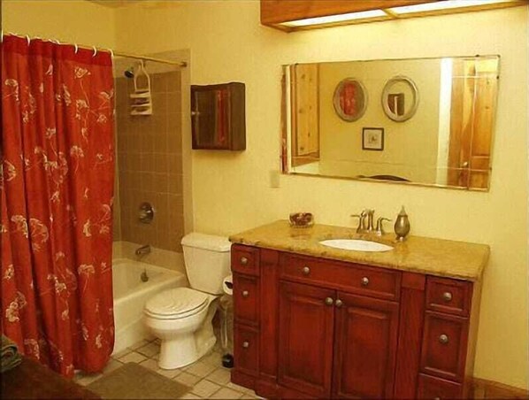 A bathroom with a toilet, sink, and vanity.