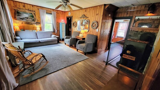 A cozy living room with a sofa, chairs, a fireplace, and a ceiling fan. - In the ❤ of Ohiopyle. Central location, clean, charming. Large yard with firepit (Ohiopyle)