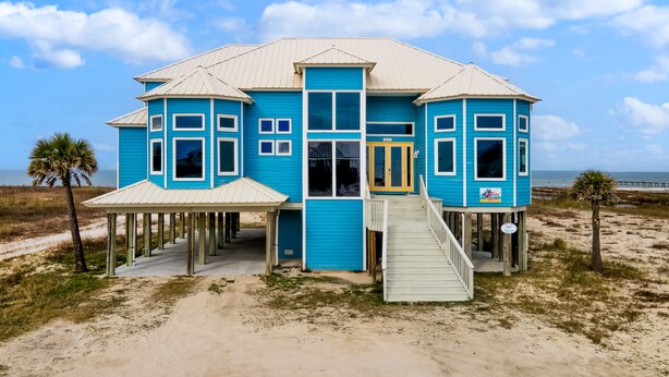 A two-story blue house with a covered porch and a staircase leading to the entrance.