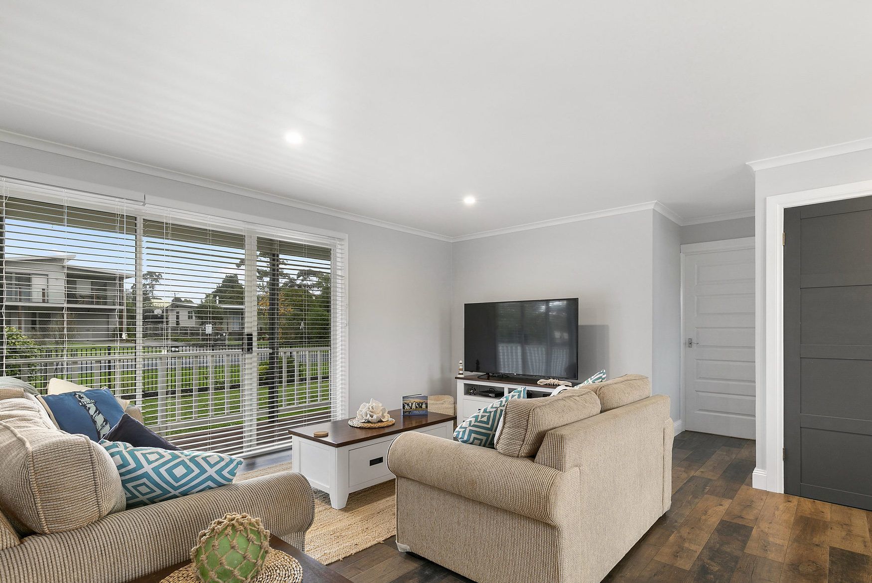 A living room with a sofa set, a coffee table, and a flat-screen TV.