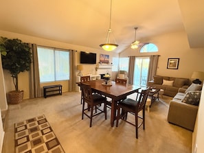 A spacious living area with a dining table, sofas, and a large window. - Perfect Getaway in Great Location! (Scottsdale)