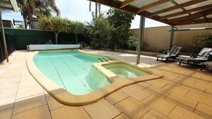 A swimming pool with a sunken hot tub, surrounded by patio furniture and a covered seating area. - Seagate Beach Retreat - with private pool and integrated spa (spa is unheated). (Rockingham)