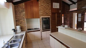 A compact kitchen with a gas stove, double oven, and a sink. - Seagate Beach Retreat - with private pool and integrated spa (spa is unheated). (Rockingham)