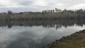 A calm river with a rocky shoreline and buildings in the background. - Studio apartment overlooking the Snake river (Clarkston)