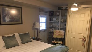 A bedroom with a bed, pillows, a lamp, a bookshelf, and a door. - Studio apartment overlooking the Snake river (Clarkston)