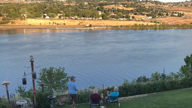 A grassy area with a view of a lake and a distant town. - Studio apartment overlooking the Snake river (Clarkston)