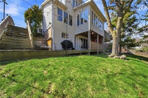 A two-story house with a front porch, a grill, and a tree in the yard. - River Views | Pool Table | EV Charger | Hiking Trails | Near Niagara Falls (St. Catharines)