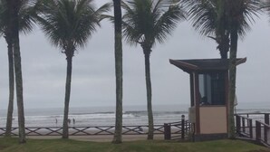 Une vue sur la plage, avec des palmiers et une petite construction en bois.