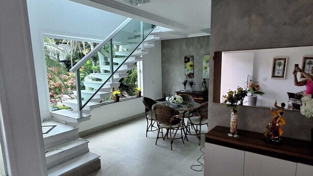 Une cuisine moderne avec un coin repas, un escalier menant à un espace extérieur et une vue sur l’extérieur.