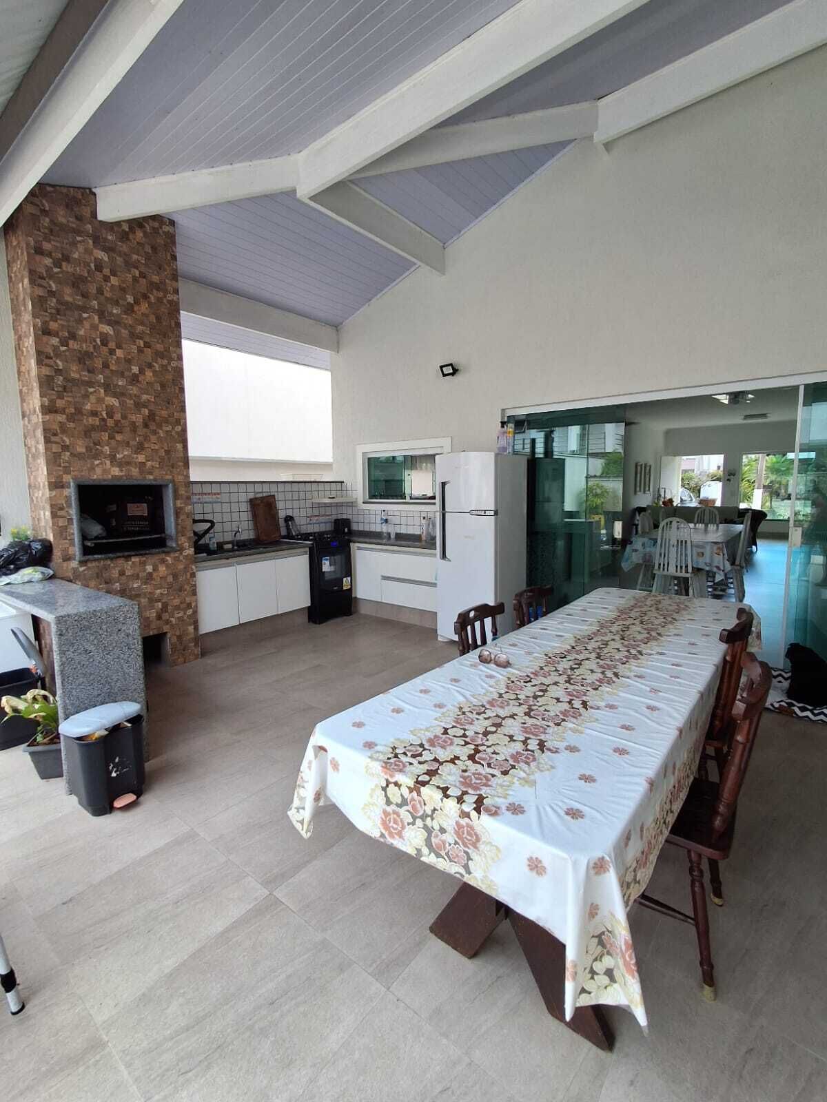 A modern kitchen with a stone accent wall, a dining area with a floral tablecloth, and a view through a glass door.