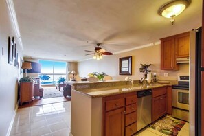 Una cocina moderna con una isla central, armarios de madera y electrodomésticos de acero inoxidable.