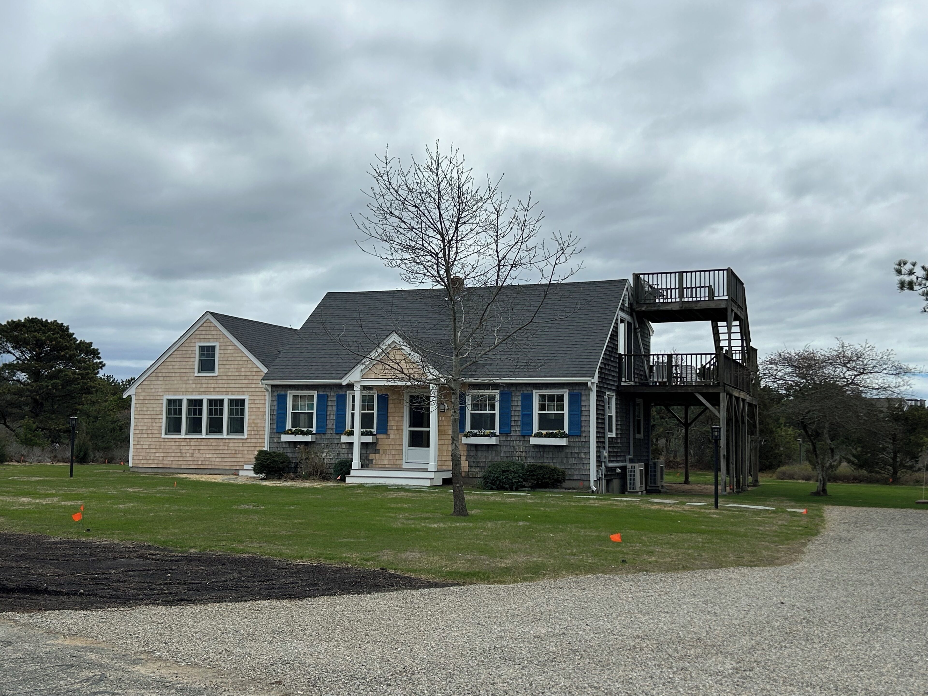 A two-story house with a balcony and a small porch.