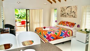 Ein Hotelzimmer mit Bett, Schreibtisch, Stuhl und Blick ins Freie.