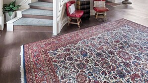 Tilava aula, jossa on näyttävä portaikko, suuri kattokruunu ja suuri, kuvioitu matto.