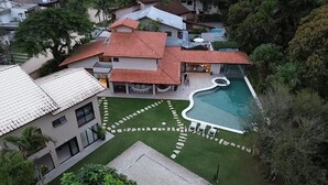 A residential property with a swimming pool, a patio area, and a well-maintained lawn.