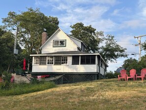 A two-story house with a front porch, a chimney, and a nameplate.