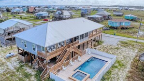 A beachfront house with a pool, wooden deck, and multiple levels. - Blessed at the Beach - Gulf View, Heated Pool and Jacuzzi. (Dauphin Island)