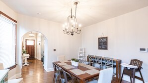 A dining area with a wooden table, metal chairs, and a chandelier.