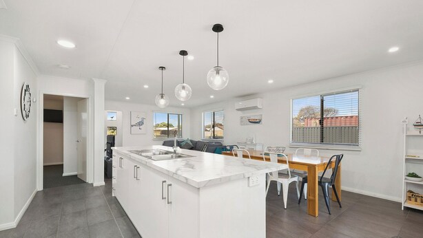 A modern kitchen with a central island, pendant lighting, and a view of the outside. - Seagulls is the ultimate seaside escape! (Lancelin)