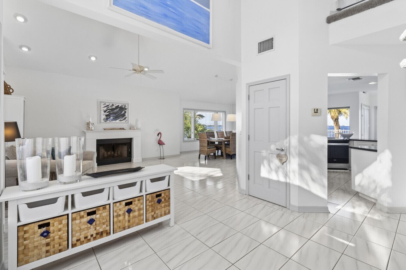 A spacious living area with a fireplace, a television, and a dining area with wicker furniture.