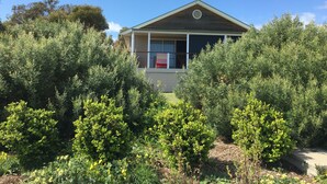 A two-story house with a balcony, surrounded by dense greenery and trees. - Private Luxury Couples Retreat The Bathhouse at Aldinga Bay. Sunsets, BeachWalks (Sellicks Beach)