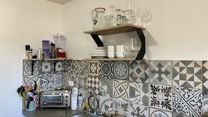 A kitchen with a tiled backsplash, a toaster, and various kitchen utensils. -  Near the best Surf beaches in San Jose del Cabo! (San José del Cabo)