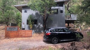 A modern building with a sign reading "JANAZA" and a black SUV parked in front. - Janaza Retreat right in the middle of Halls Gap township. Pet friendly. (Halls Gap)