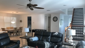 Ein modernes Wohnzimmer mit einer Couch, einem Couchtisch und einem Essbereich mit Tisch und Stühlen.
