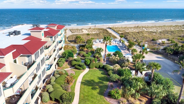 A resort with a pool, beachfront view, and a well-maintained garden. - Ocean View Condo | Pool, Private Beach Access, Elevator, Sleeps 8 (Tybee Island)