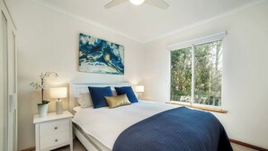 A bedroom with a bed, bedside tables, a window, and a ceiling fan. - Uninterrupted Views Encounter Bay (Encounter Bay)