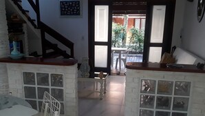 A spacious living area with a staircase, a dining table, and a view of the outdoor patio. - Juquehy, beachfront, almost on the sand, special offer February/26, 6 people. (São Sebastião)