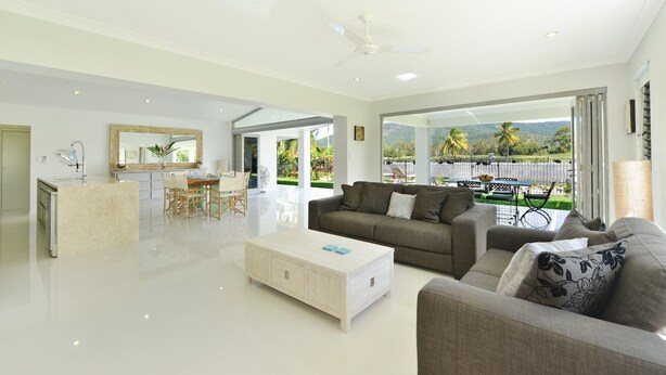 A spacious living area with a modern kitchen, a dining table, and a sofa.