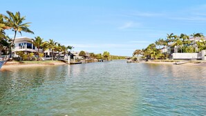 A waterfront property with modern architecture, a marina, and palm trees. - Noosa Sound, waterfront, amazing value (NOOSA HEADS)