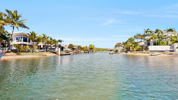 A waterfront property with modern architecture, a marina, and palm trees. - Noosa Sound, waterfront, amazing value (NOOSA HEADS)
