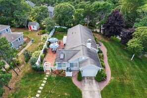 A residential property with a two-car garage, a covered patio area, and a well-maintained lawn.