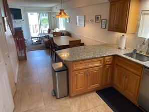 A modern kitchen with granite countertops, wooden cabinets, and a stainless steel sink.