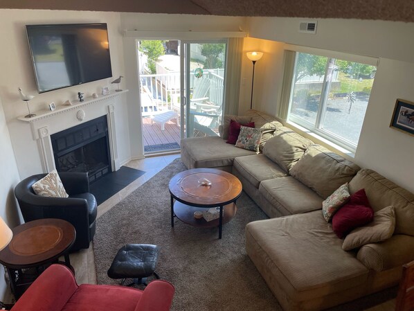 A living room with a fireplace, a sofa, a coffee table, and a television.