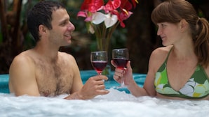Una pareja en un jacuzzi con un ramo de flores.
