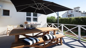 A wooden deck with a picnic table and benches, a large black umbrella, and a white railing. - THE WHITE HOUSE luxury villa embedded in history (Penola)
