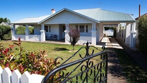 A single-story house with a covered porch, a small garden, and a metal fence. - THE WHITE HOUSE luxury villa embedded in history (Penola)