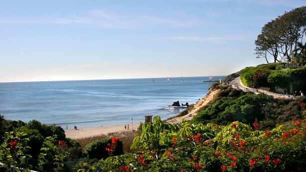 A coastal landscape with a beach, a pathway, and a view of the sea. - Luxury beach home with outside fireplace and dining, 10 minute walk to beach  (Newport Beach)