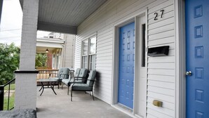 A covered porch with three chairs and a table, a blue door with the number 27, and a mailbox. - Relax & Feel At Home During Your Pittsburgh Stay (Pittsburgh)