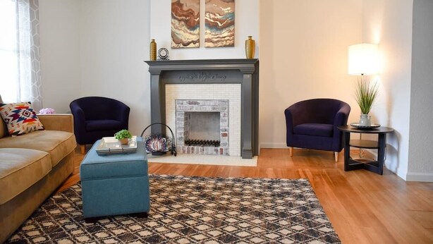 A living room with a fireplace, two armchairs, a sofa, and a patterned rug. - Relax & Feel At Home During Your Pittsburgh Stay (Pittsburgh)