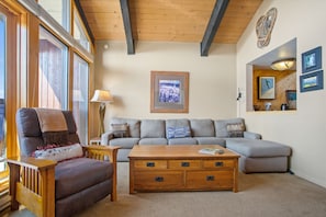 A cozy living room with a sofa, a wooden coffee table, and a lamp.